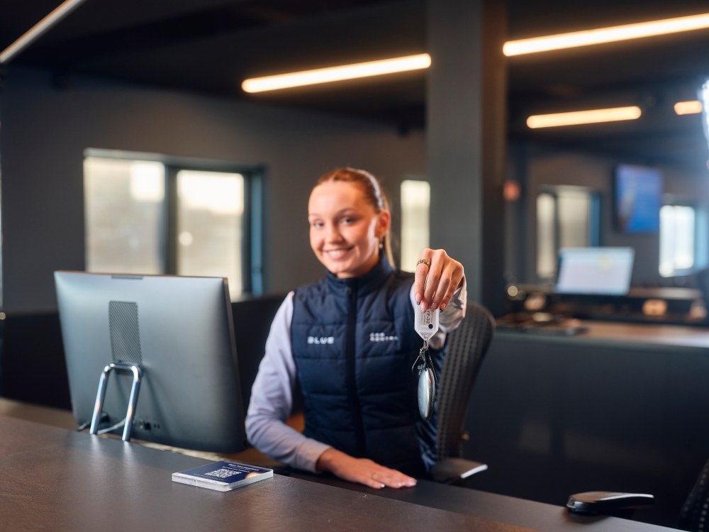 Blue car rental kef airport office. Blue Car rental staff hending over a key to a customer at Kef airport office.