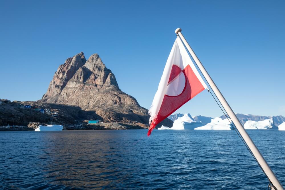 Greenland flag. Greenland flag and icebergs seeing from a boat in Greenland.