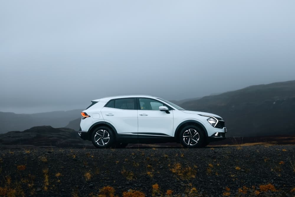 Mid-size rental car. White Kia Sportage 4x4 rental car.