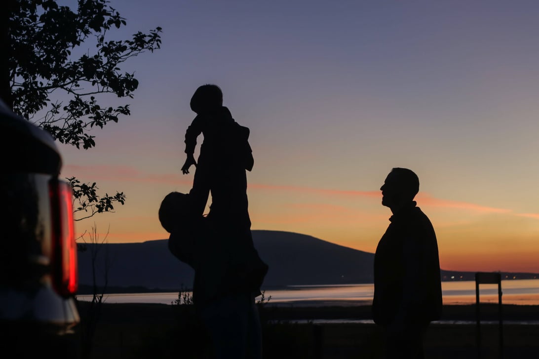 Family in iceland with kids in the air and sun.