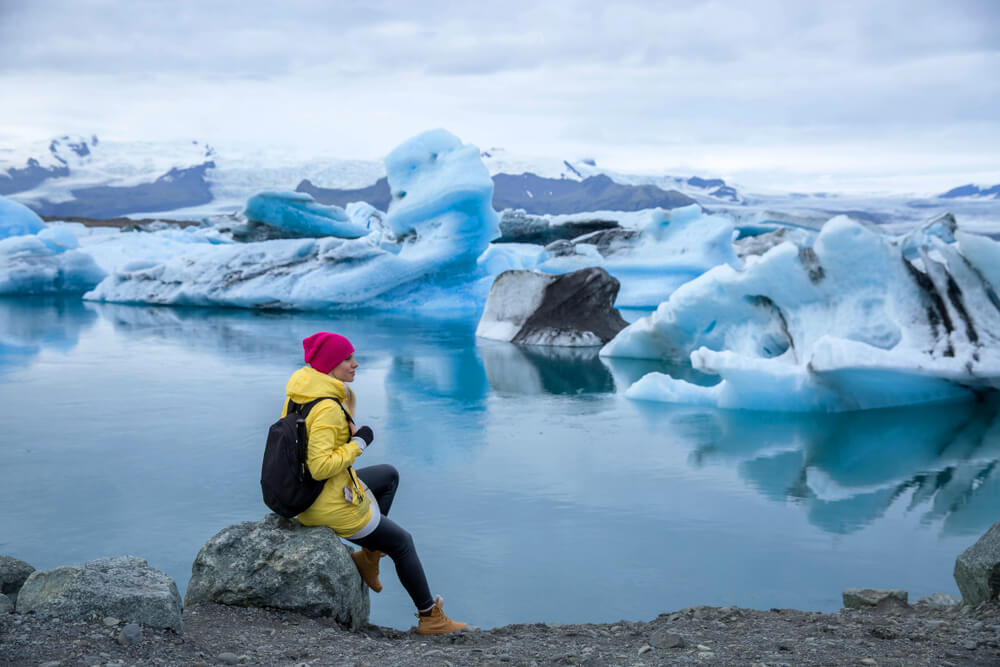 Women sitting on the bank of Jökulsárlón, glacier lagoon