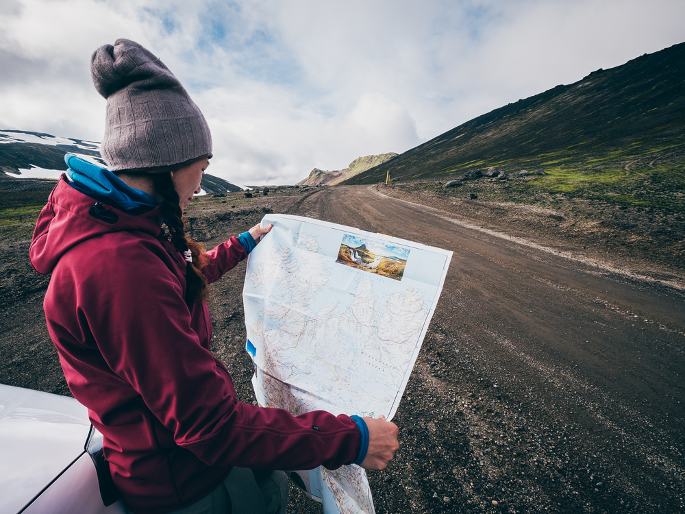 Iceland paper map. Women looking at a paper map in Iceland.