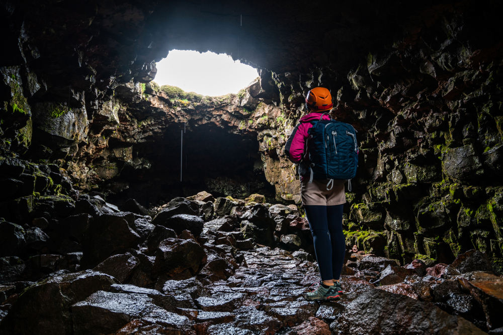 Raufarhólshellir. Traveler exploring Raufarhólshellir a lave tunnel cave near Reykjavik in Iceland.