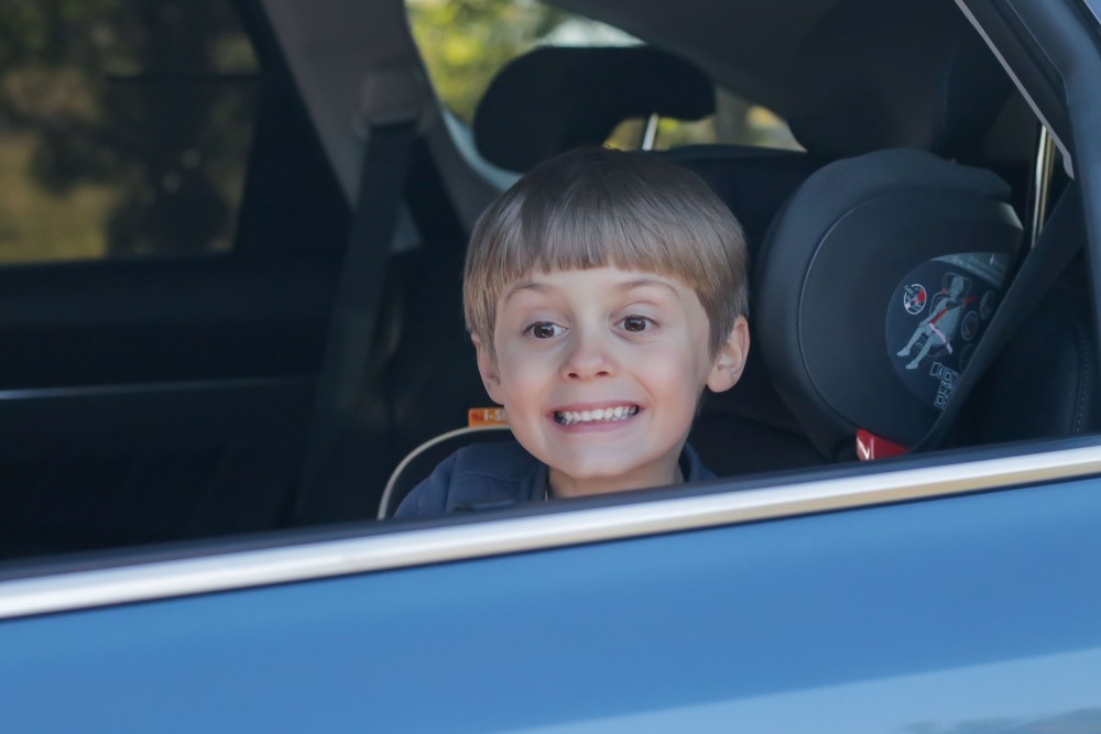 Blue car rental smile. Child smiling while sitting in a seat from Blue car rental.