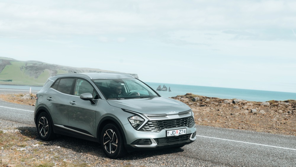 Blue car rental on Iceland south coast. Kia Sportage rental car at Dyrhólaey south Iceland.