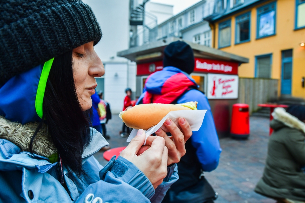 Hot dog stand in Reykjavik. Women eating a traditional hot dog from a famous stand in Reykjavik.