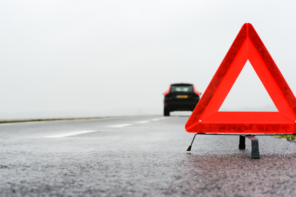 Warning tringle on roadside in Iceland. Red tringle on a road in Iceland for assistance.