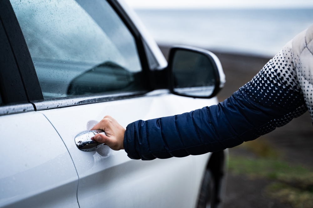 Iceland car rental door. Customer reaching for the handle on a car door in Iecland.