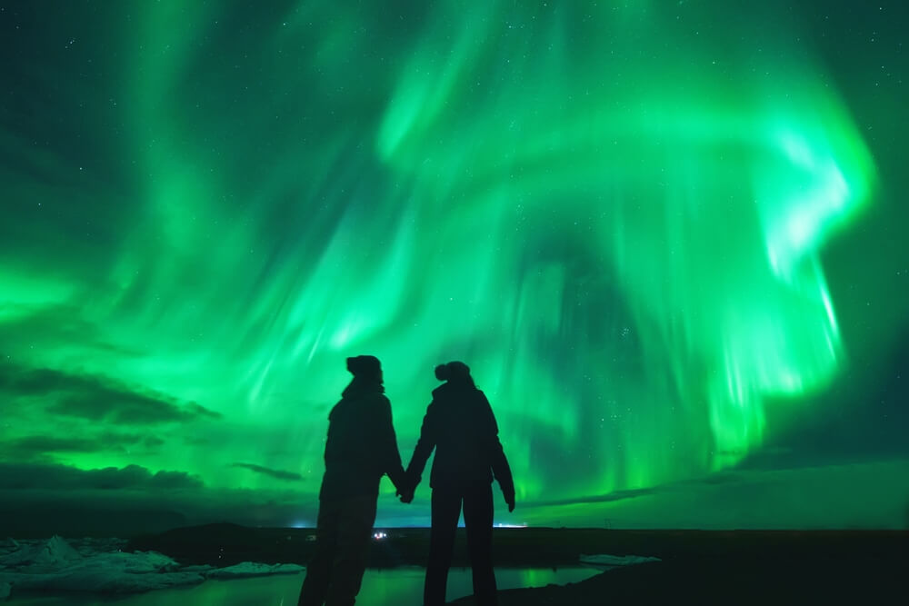 Couple looking at the Northern lights on Valentines day in Iceland.