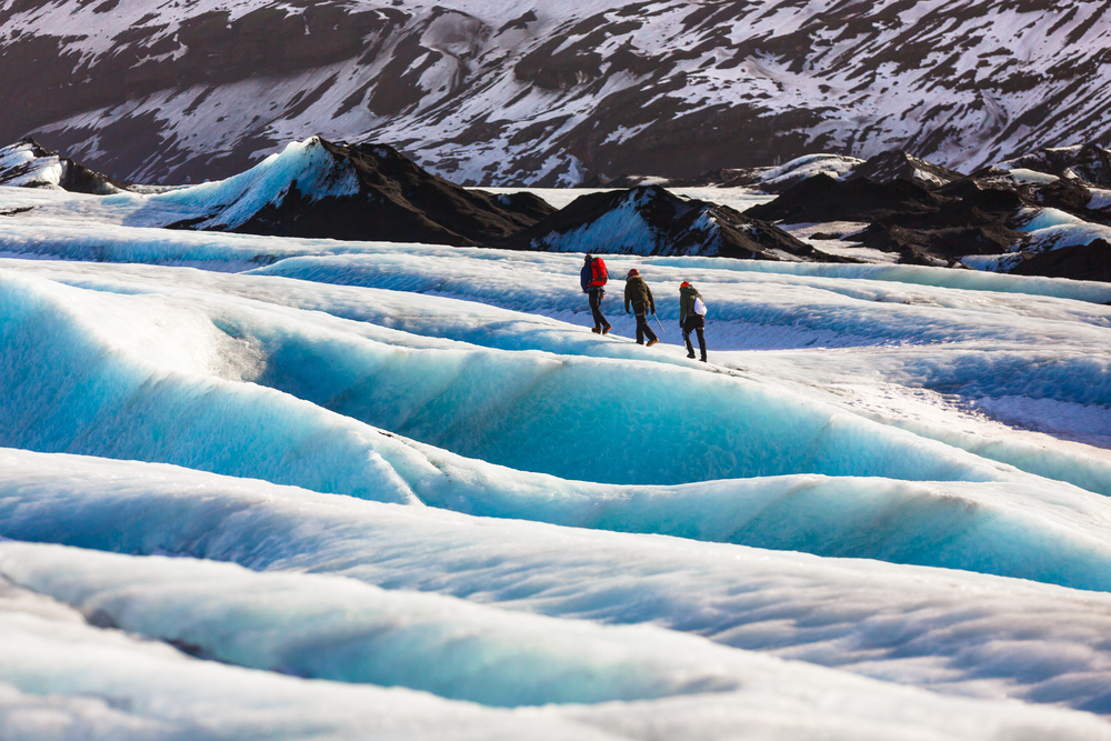 Vatnajokull ice seat. Three people walking on the ice seat at Vatnajokull glacier.